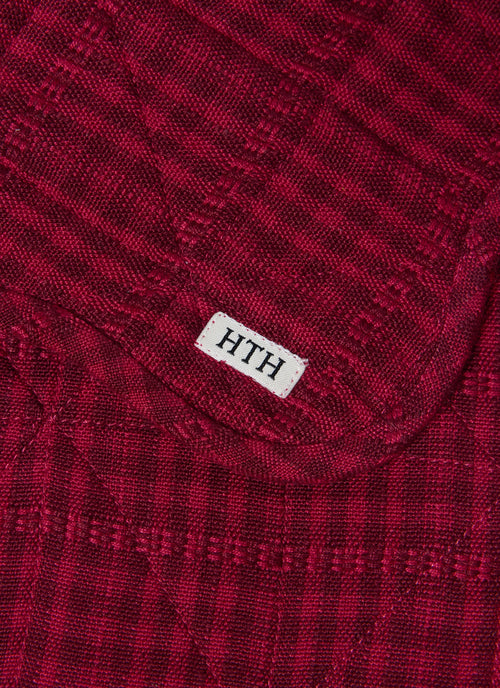 Close-up of a red textured fabric with 'HTH' label