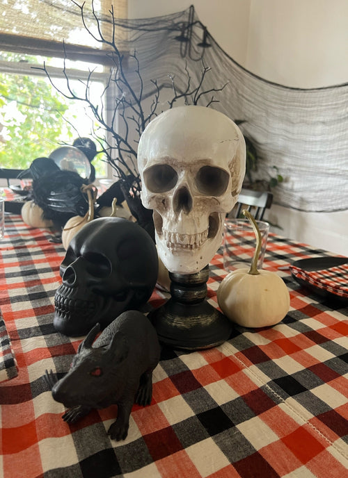 Halloween-themed decorations including skulls and pumpkins on a checkered tablecloth.
