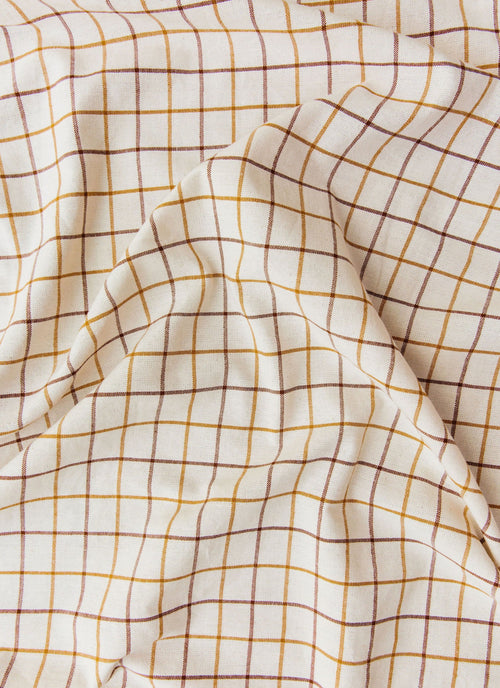 Close-up of checkered fabric with yellow lines on a white background