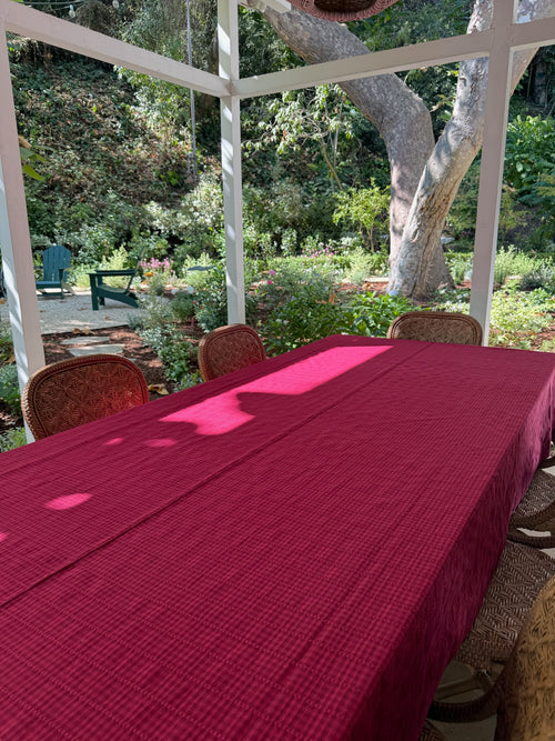 Red tablecloth on a table with chairs in an outdoor setting