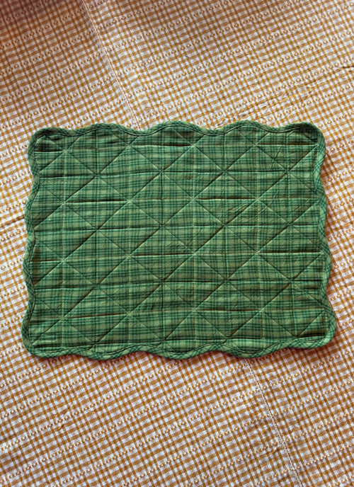 Green quilted square on a brown checkered background
