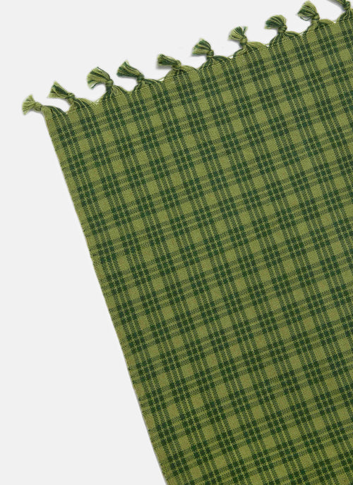 Green plaid fabric with tassels on a white background