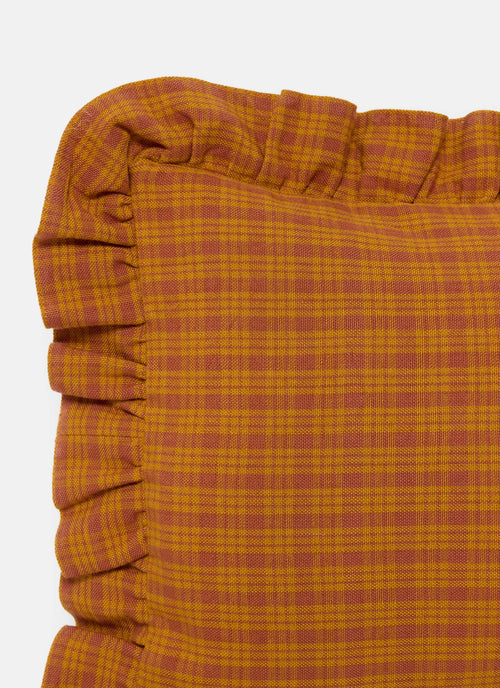 Close-up of a orange checkered fabric with ruffled edge on a white background