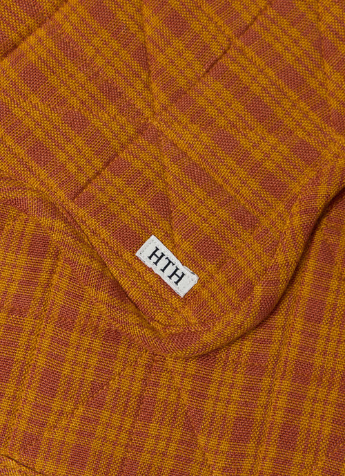 Close-up of a textured fabric with a brand label on a checkered pattern.
