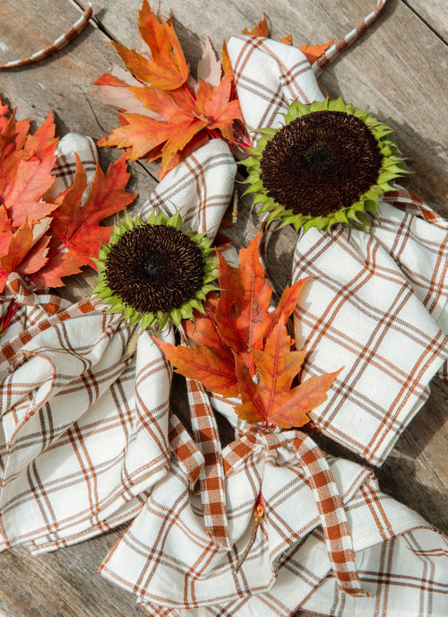Plaid Napkins with sunflowers and autumn leaves on a wooden surface