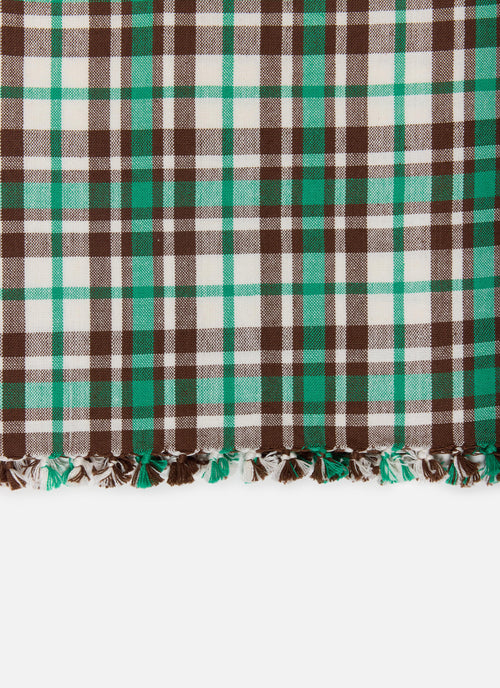 A close-up of a plaid  fabric with fringe at the bottom, featuring green, brown, and off-white stripes in a tartan pattern.