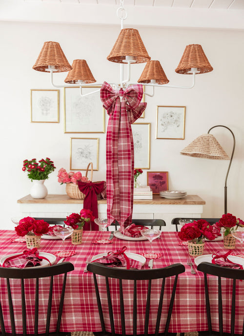 Dining room with a red plaid tablecloth, chairs, and decorative elements.