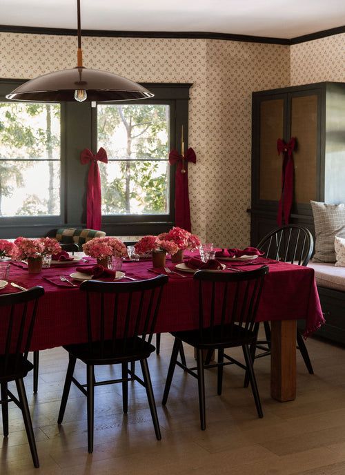 Dining room with a table set for a meal, purple tablecloth, and floral centerpieces.