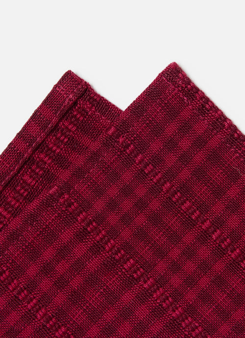 Close-up of a red textured fabric with a subtle pattern on a white background