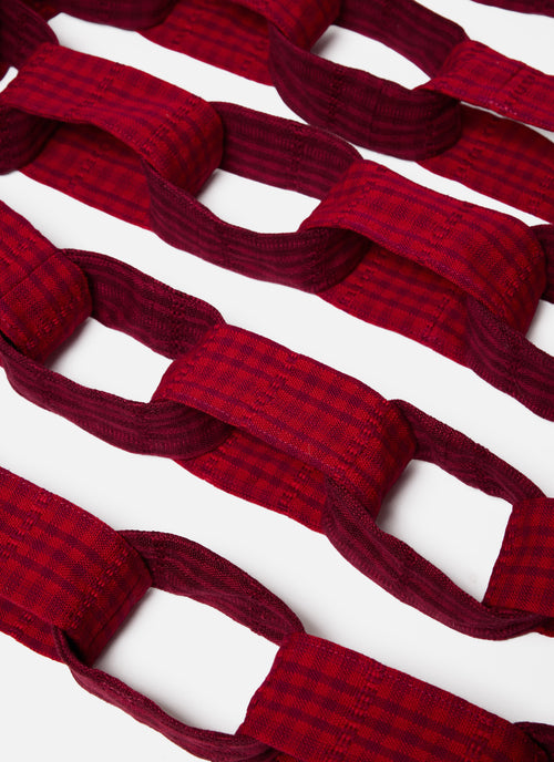 Red fabric strips arranged in a pattern on a white background