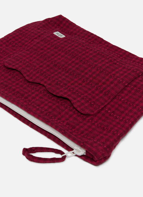 Red textured pouch with a zipper on a white background