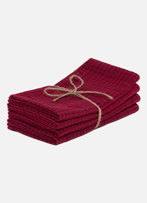Stack of red napkins tied with twine on a white background