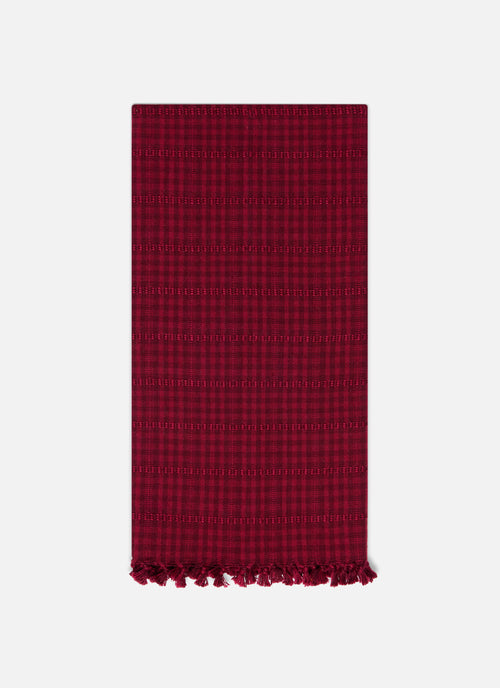 Red checkered towel with tassels on a white background