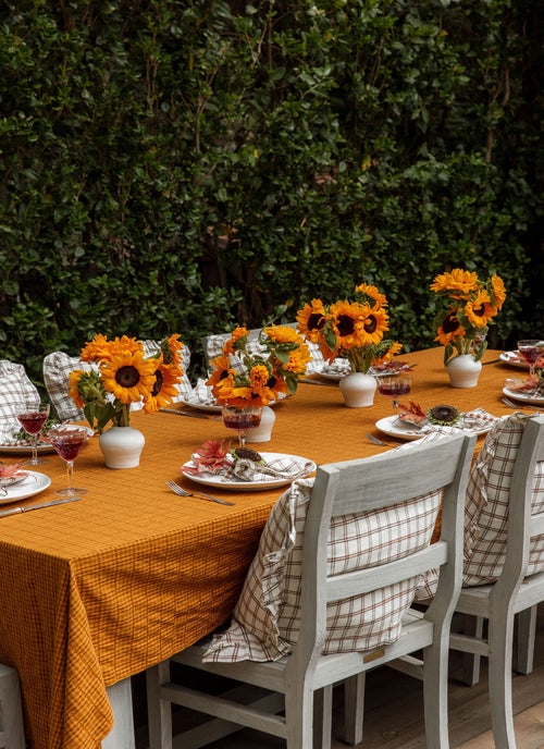 Dining table set with sunflower centerpieces outdoors