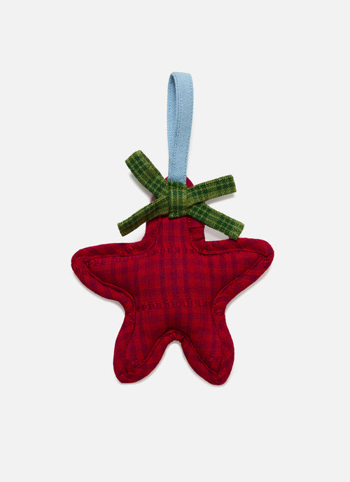 Red star-shaped fabric ornament with green bow on a white background