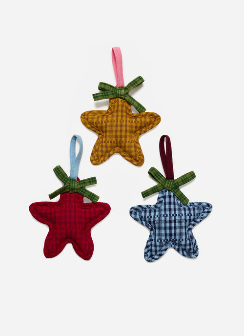 Three star-shaped fabric ornaments in red, yellow, and blue on a white background
